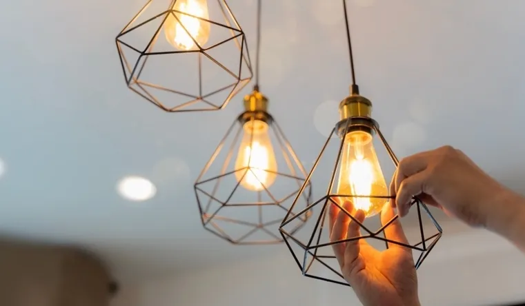 Domestic electrician fitting pendant lights in a Falmouth home