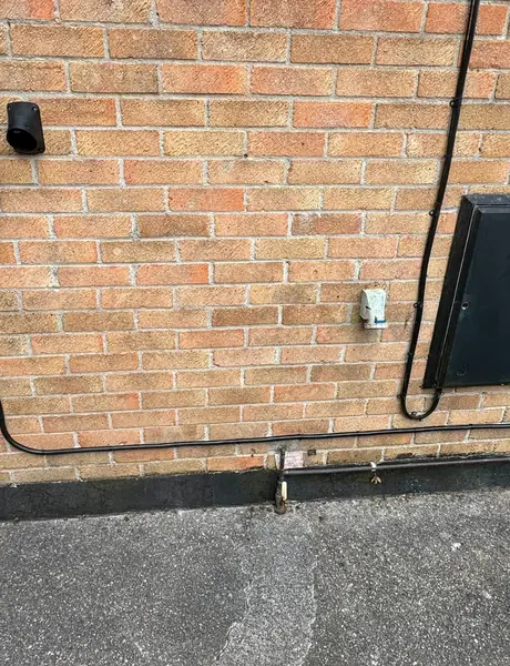 Outdoor electrics with an external cable run and fittings on a brick wall