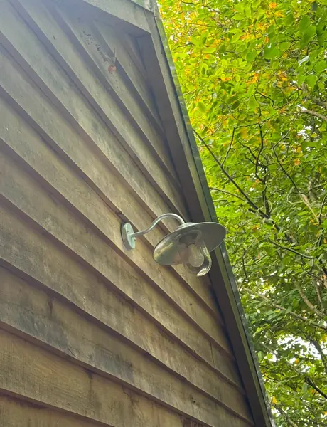 Outdoor wall light installed on timber cladding