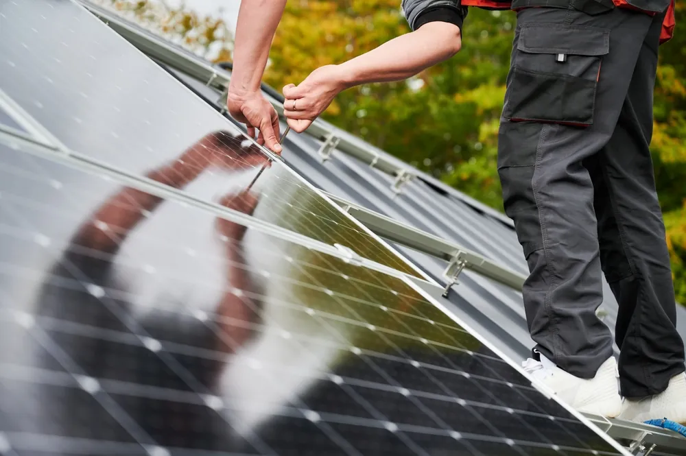 Installers fitting solar PV panels on a roof in Cornwall
